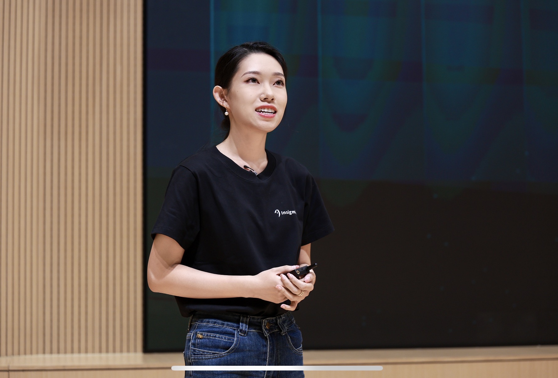 Tina speaking on stage at a presentation